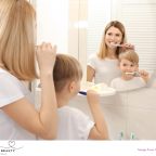 image of mum and son brushing their teeth while looking in the mirror