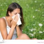 picture of a woman blowing nose outside due to hayfever