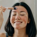 picture of a woman applying a face mask as part of a night time skincare routine