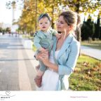 picture of a mum holding a baby with hair and make up on wearing nice clothes