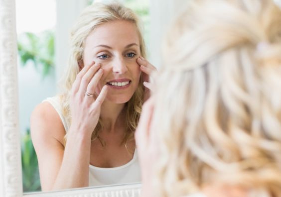 picture of a a middle age woman looking at herself in a mirror