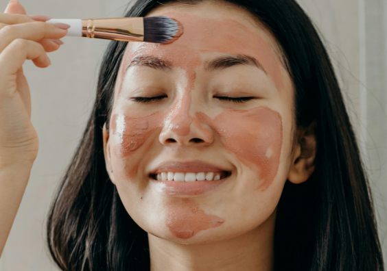 picture of a woman applying a face mask as part of a night time skincare routine