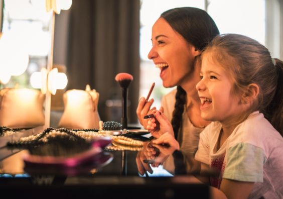 picture of a happy mum and daughter experimenting with makeup