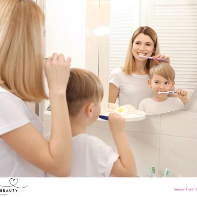 image of mum and son brushing their teeth while looking in the mirror