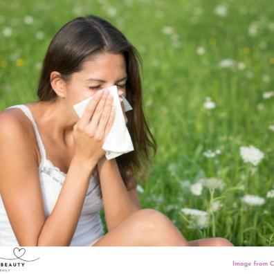 picture of a woman blowing nose outside due to hayfever