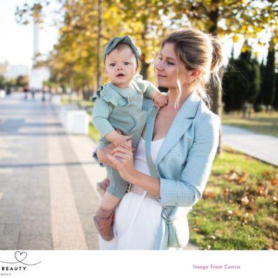 picture of a mum holding a baby with hair and make up on wearing nice clothes